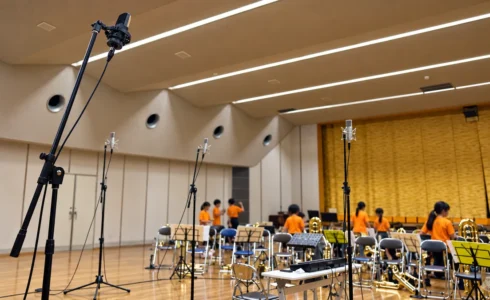 小学校のホールに複数のマイクを配置し、金管楽器の出張レコーディングを準備している様子